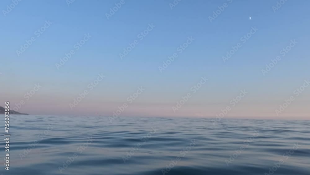 View from the surface of the sea at sunset. Chilling on the sea waves and watching the setting sun go below the horizon View from the surface of the sea at sunset. Chilling on the sea waves and watching the setting sun go below the horizon