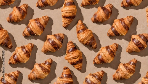 pattern with croissant on beige studio background; many corissants harsh light