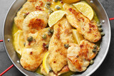 Delicious chicken piccata with lemons on grey table, top view