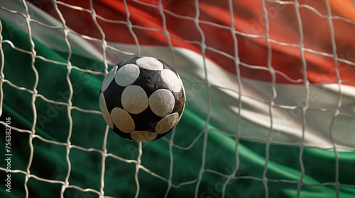 Soccer ball in the net with the flag of Hungary in the background © Petrova-Apostolova