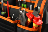 Bag with different pliers and other repair tools, closeup. Space for text