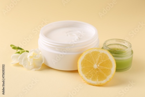 Wallpaper Mural Moisturizing cream in open jars, lemon and freesia flower on beige background. Body care products Torontodigital.ca