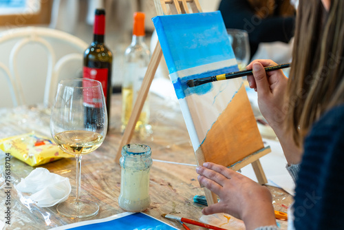 Art and Wine workshop. Middle aged woman learning to paint. photo