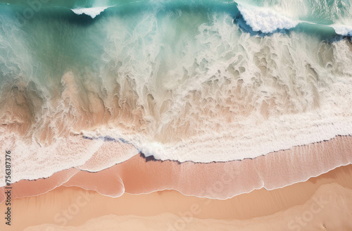 Beach and waves from the top view and the wave has a white foam. The sand is a light brown color.