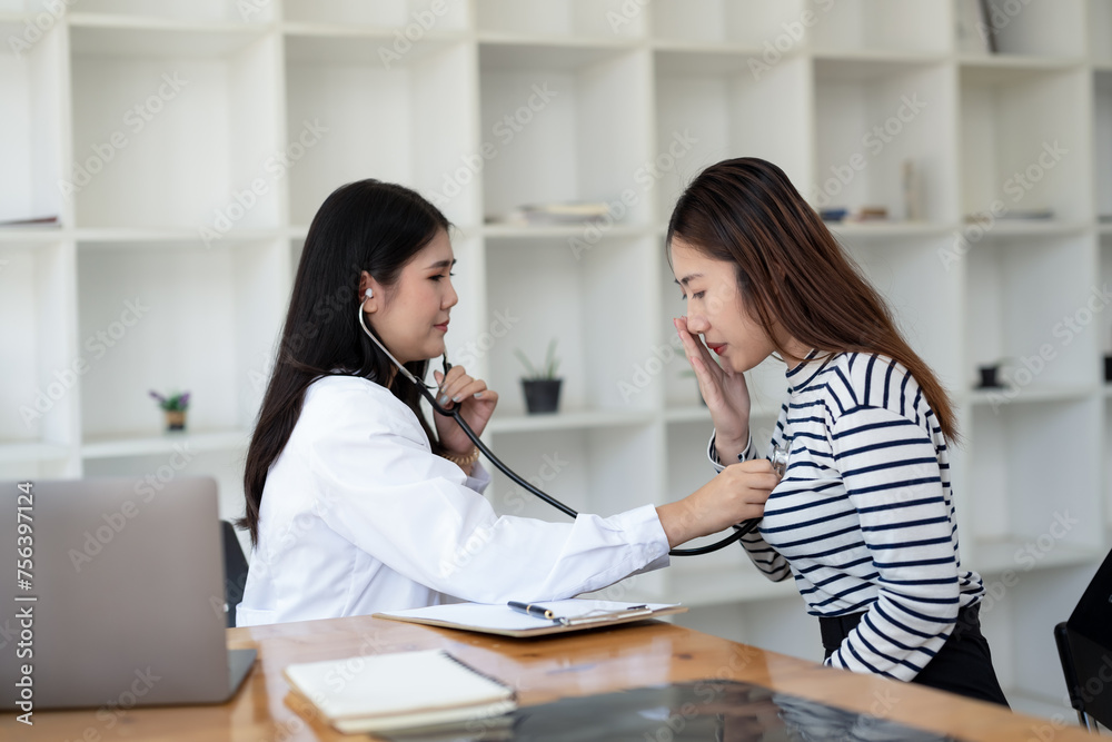 Female doctor using stethoscope to examine patient in doctor's office Female doctor using stethoscope to examine patient in doctor's office