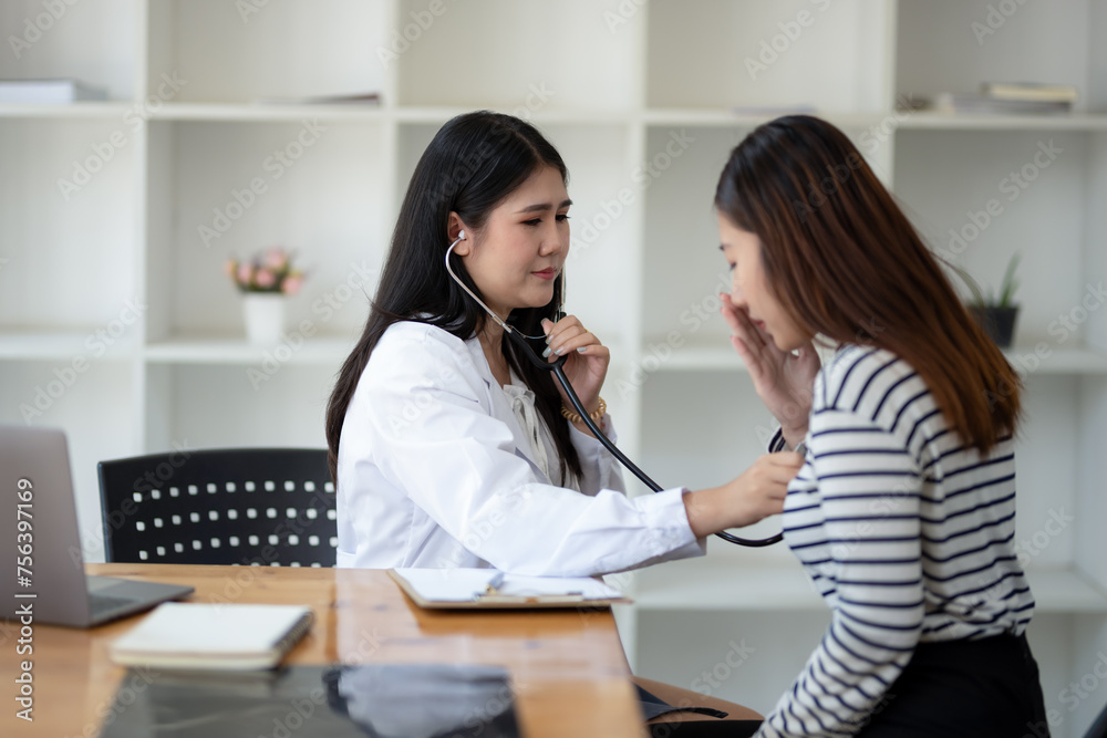 Female doctor using stethoscope to examine patient in doctor's office Female doctor using stethoscope to examine patient in doctor's office