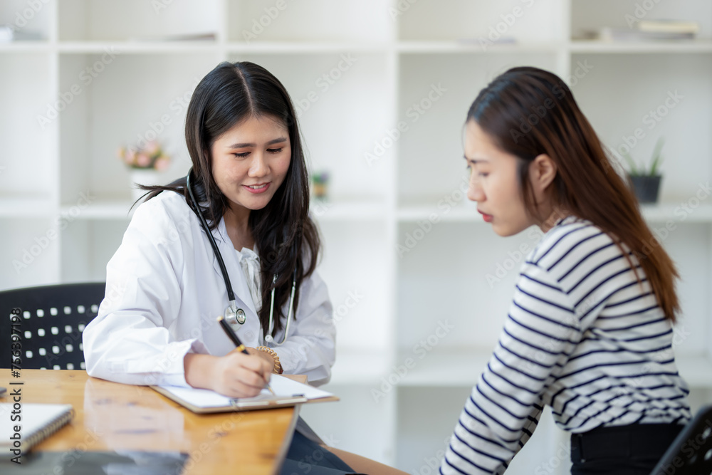 Attentive female doctor taking notes while consulting a patient in a modern medical office. Attentive female doctor taking notes while consulting a patient in a modern medical office.