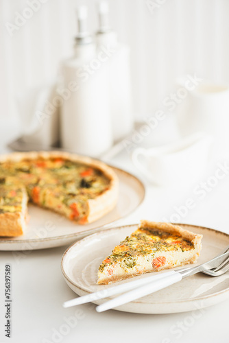 French quiche lauren with salmon, cheese and broccoli on white table. Soft focus