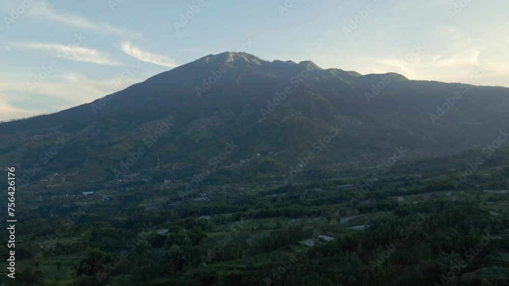 Fly over Indonesian rural landscape with Mount Merbabu on the background in the morning. 4K aerial drone shot of Indonesian countryside.