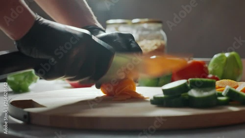 Chef using a knife cutting fresh raw sqaush. Cooker at restraunt making a healthy vegetable meal.  photo