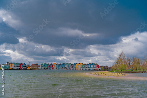 Colourful wooden lakeside houses De Rietplas. Modern residential architecture in Houten, The Netherlands