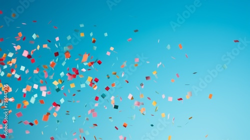 Festive multicolored confetti flying on a blue background from the copy space. A horizontal banner for Advertising and Text.