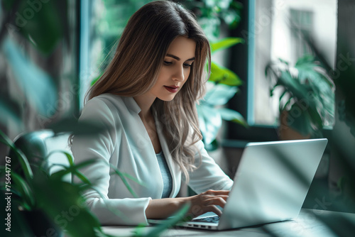 Businesswoman working on laptop computer at office. Business woman using portable computer surfing the internet searching the information online working e-learning concept photo