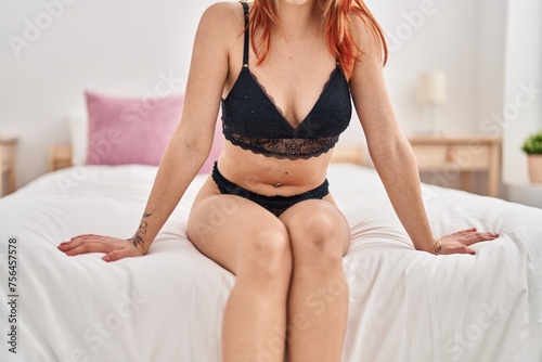Young caucasian woman wearing lingerie sitting on bed at bedroom © Krakenimages.com
