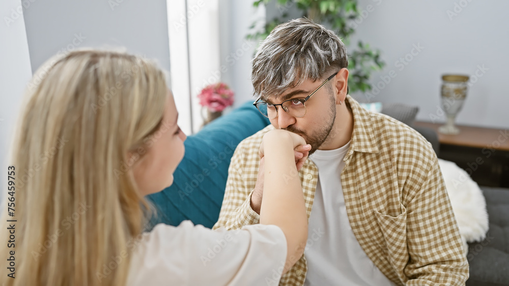 A supportive woman comforting a pensive man in a cozy living room, portraying a loving relationship amid a homely setting