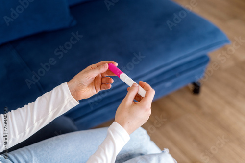 Billede på lærred Woman hands with home pregnancy test, checking results of artificial inseminatio