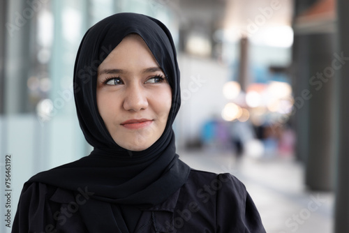 Urban Muslim Woman looking up, portrait of a Happy, Smiling and Confident Young Woman in the City with Hijab, concept image of Muslim people lifestyle, hope, looking, searching, finding, discovery