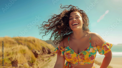 Radiantly smiling young woman with luscious curly hair enjoys a sunny day at the beach wearing tropical-print dress. Essence of a relaxed, cheerful beach holiday, filled with laughter and sunshine.