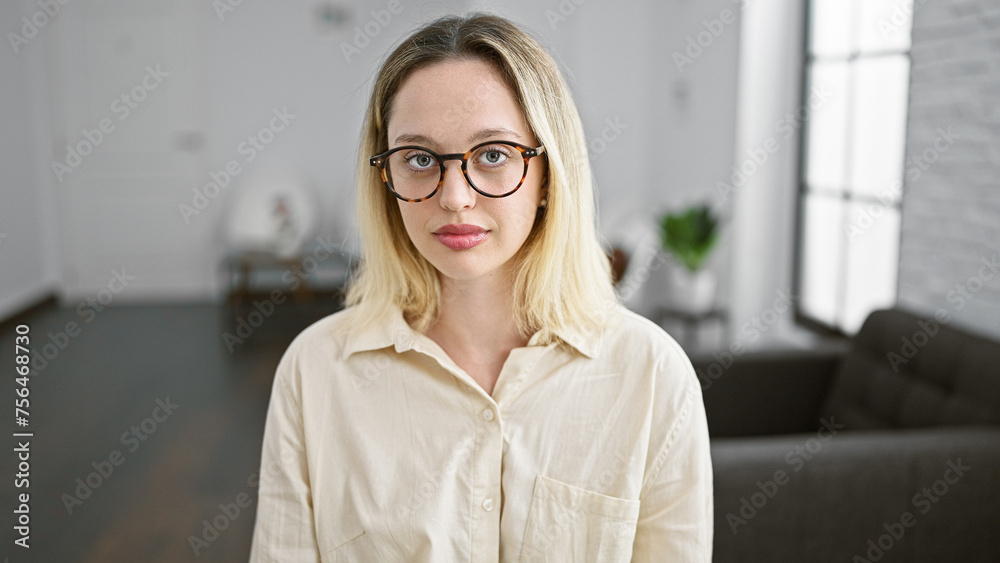 Young blonde woman business worker with serious face at the office