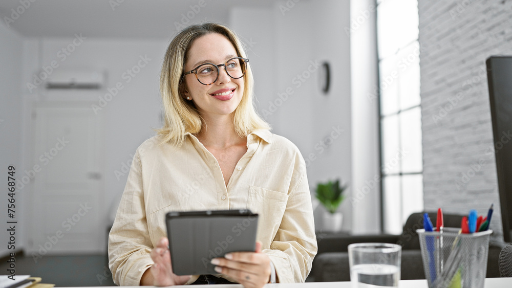 Young blonde woman business worker using touchpad smiling at the office Young blonde woman business worker using touchpad smiling at the office