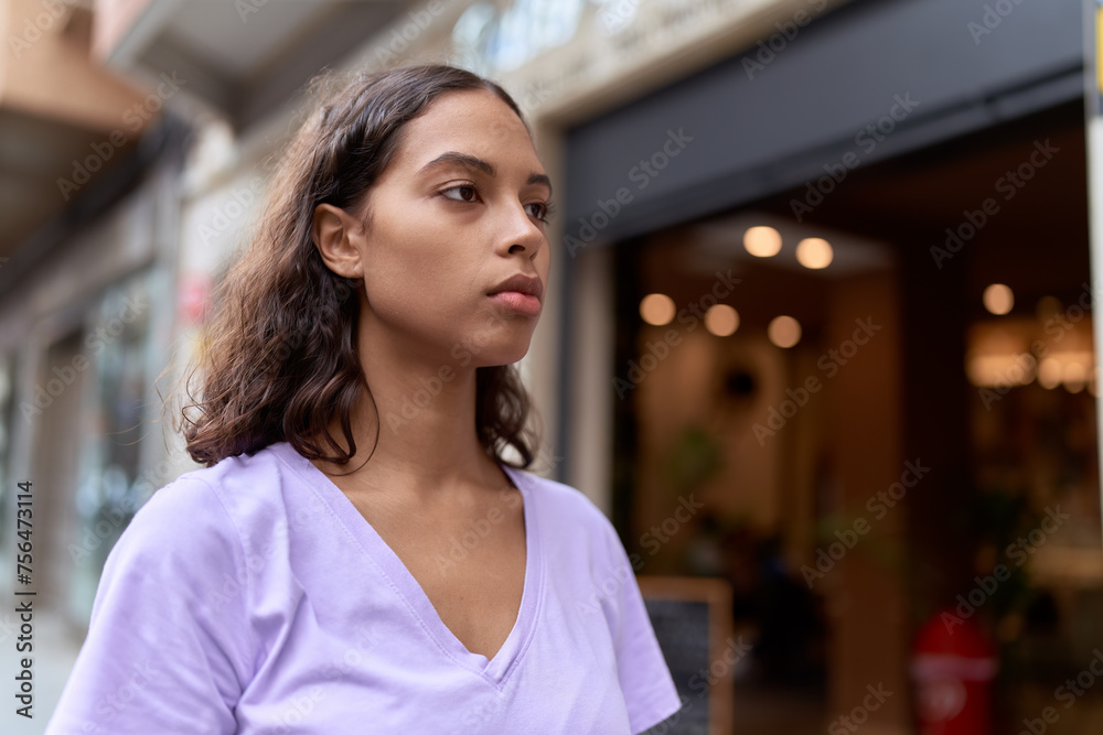 Young african american woman looking to the side with serious expression at street - obrazy, fototapety, plakaty 