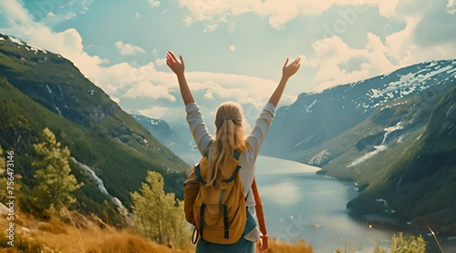Girl on the top of mountain with hands up, green islands view behind photo