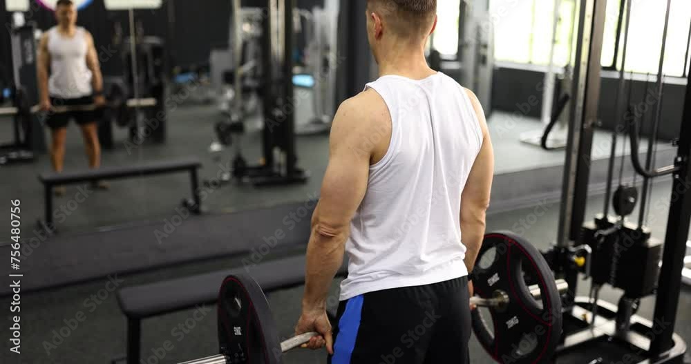 Athlete man lifting barbell in gym 4k movie slow motion. Power load on arm muscles concept Athlete man lifting barbell in gym 4k movie slow motion. Power load on arm muscles concept