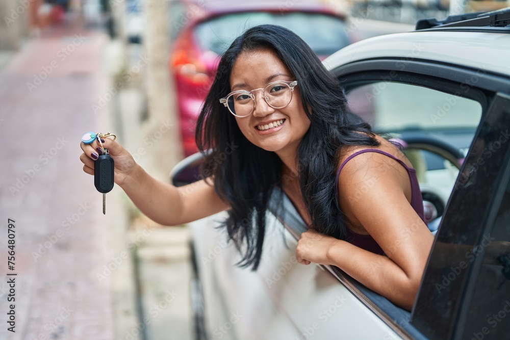 Young chinese woman smiling confident holding key of new car at street Young chinese woman smiling confident holding key of new car at street