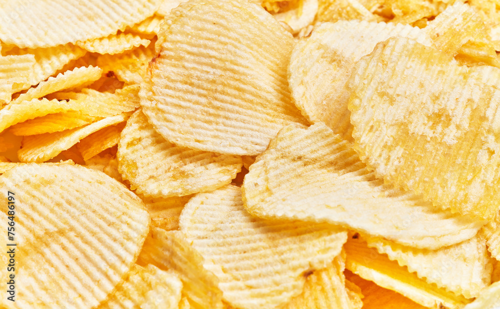 Close-up of golden crispy potato chips textured background with ridges, ideal for food and snack themes. Close-up of golden crispy potato chips textured background with ridges, ideal for food and snack themes.