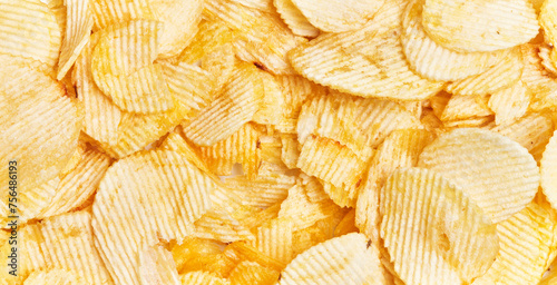 Close-up view of abundant crispy potato chips filling the frame for a textured background