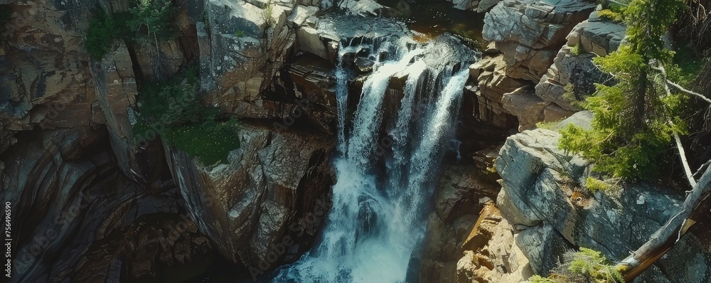 Fototapeta premium Aerial view of a breathtaking waterfall in rock cliff