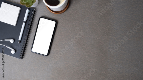 Flat lay smart phone with blank screen, sticky note, coffee cup and books on grey table. Copy space for your text.