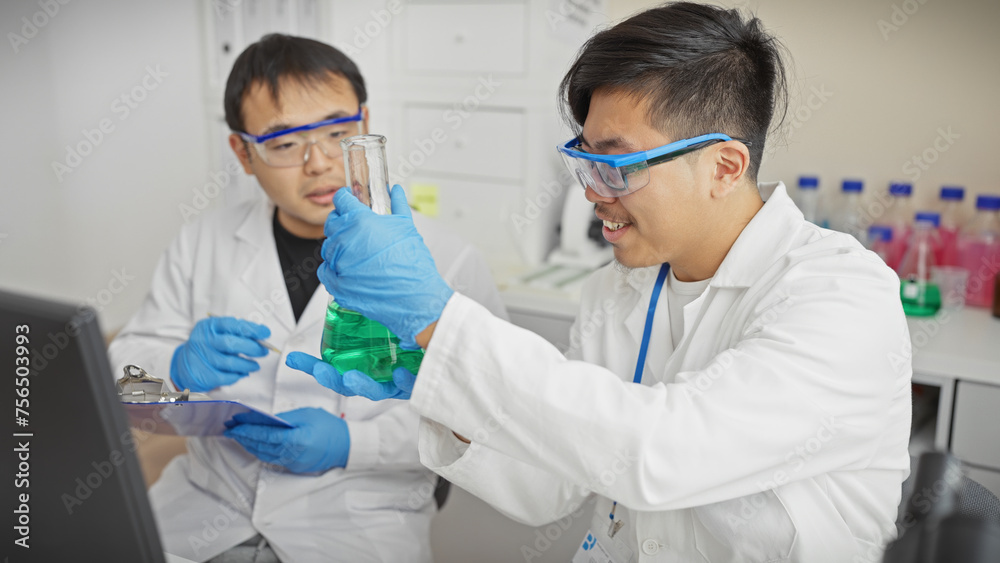 Two men in lab coats examining chemical flasks in a laboratory setting. Two men in lab coats examining chemical flasks in a laboratory setting.