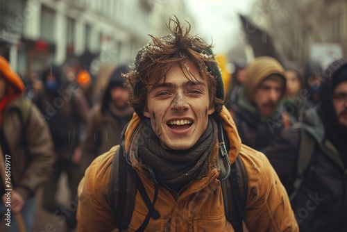 An upbeat young man smiling in a crowd with other demonstrators in a busy urban environment