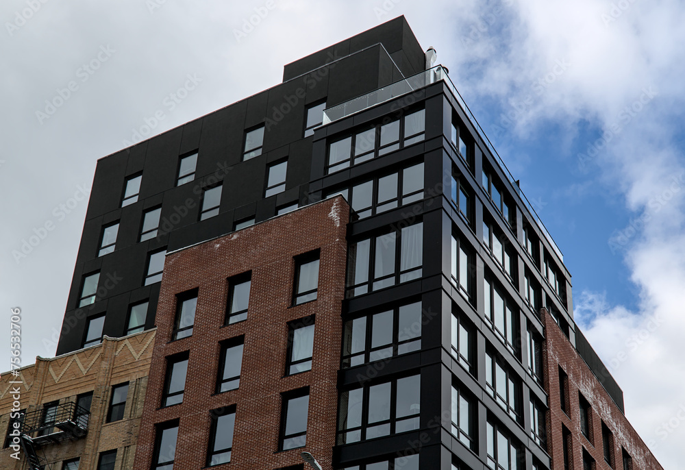 modern residential apartment building in brooklyn, new york (luxury condo high rise real estate units) co-op housing detail (windows reflecting sky, clouds) urban dwelling home new construction