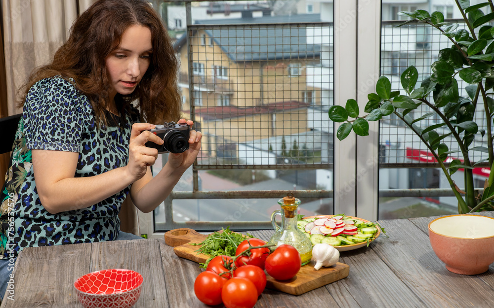 Culinary blogger taking a photo of vegetable salad ingredients at home. A woman with a high quality compact camera. Culinary blogger taking a photo of vegetable salad ingredients at home. A woman with a high quality compact camera.