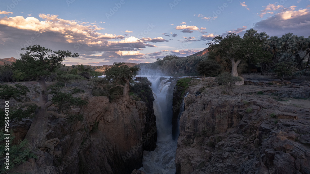 waterfall between baobab trees