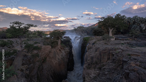 waterfall between baobab trees