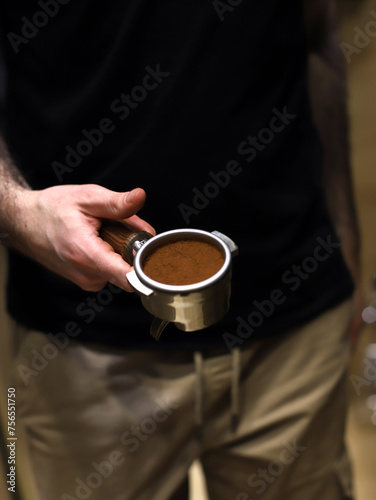 barista sosteniendo un filtro de café con café molido