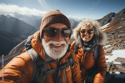 Senior couple taking a selfie at mountain viewpoint while mountaineering