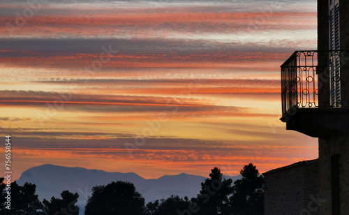 Balcone affacciato su di uno strepitoso tramonto di nuvole colorate sopra le montagne dell’Appennino photo