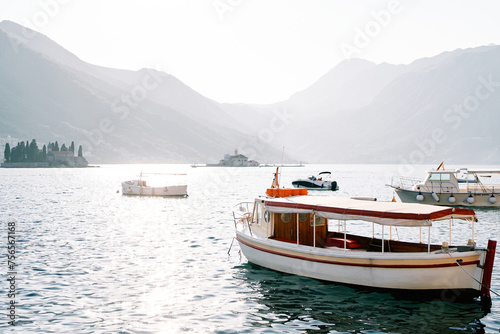 Moored excursion boats and motorboats at sea against the backdrop of the islands of the Bay of Kotor. Perast, Montenegro