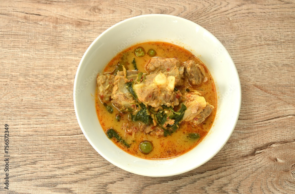 boiled pork bone with basil and chili in coconut milk curry soup on bowl