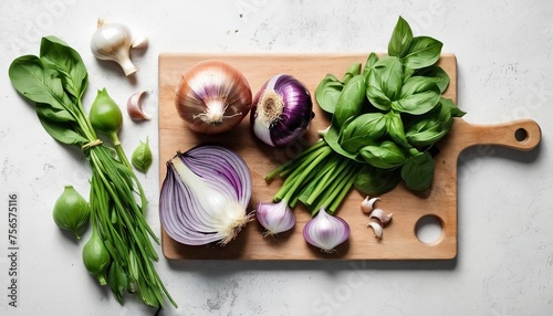Fresh coriander and basil served on wooden board with charlotte onions, metal cleaver and garlic photo