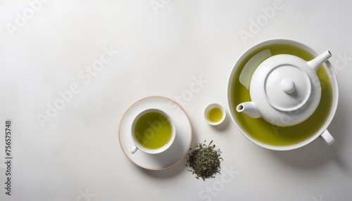 Green tea with ceramic teapot over a white texture background photo