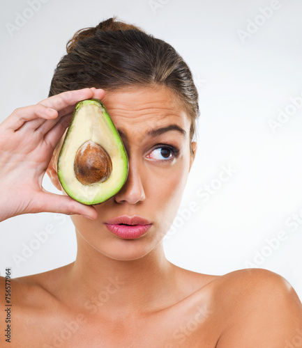Woman, face and avocado for health in studio for wellness detox, healthy skin and hydration with omega 3. Model, person and fruit for organic cosmetics, natural beauty or skincare on white background