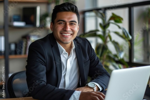 Young successful hispanic businessman inside office, man smiling and looking at camera sitting at desk using laptop, experienced boss in suit, investor successful financier at work, Generative AI © The Picture House