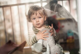 Portrait of cute baby boy with stuffed toy looking out window, looking sad. Love and family emotion