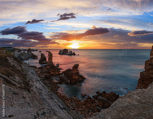 Sunset Arnia Beach (Spain, Atlantic Ocean) coastline landscape. photo