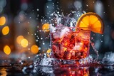 Stunning Negroni cocktail splashing with orange slice on a radiant black background
